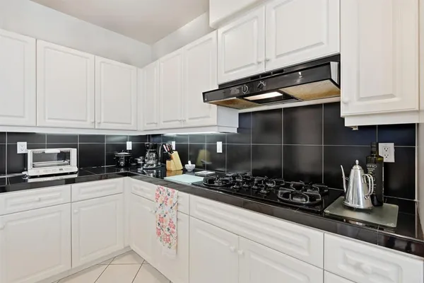 a kitchen with stainless steel appliances granite countertop a sink a stove and cabinets