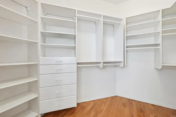 a view of walk in closet with empty racks