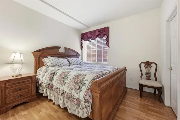 a bedroom with a bed and a lamp on dresser