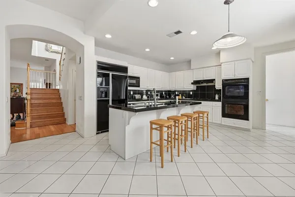 a kitchen with stainless steel appliances kitchen island granite countertop a refrigerator and a stove top oven