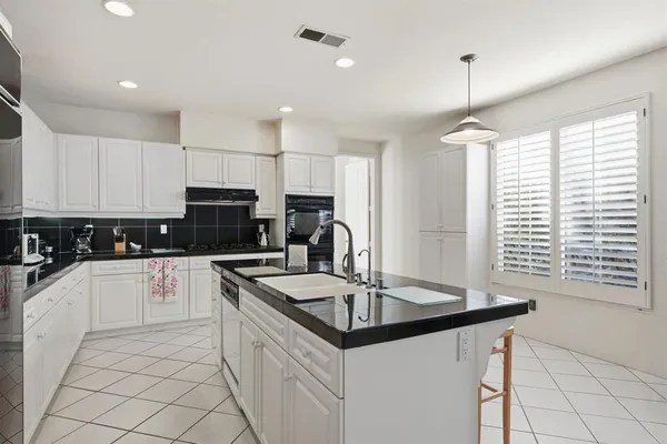 a kitchen with stainless steel appliances granite countertop a sink a stove a refrigerator and cabinets