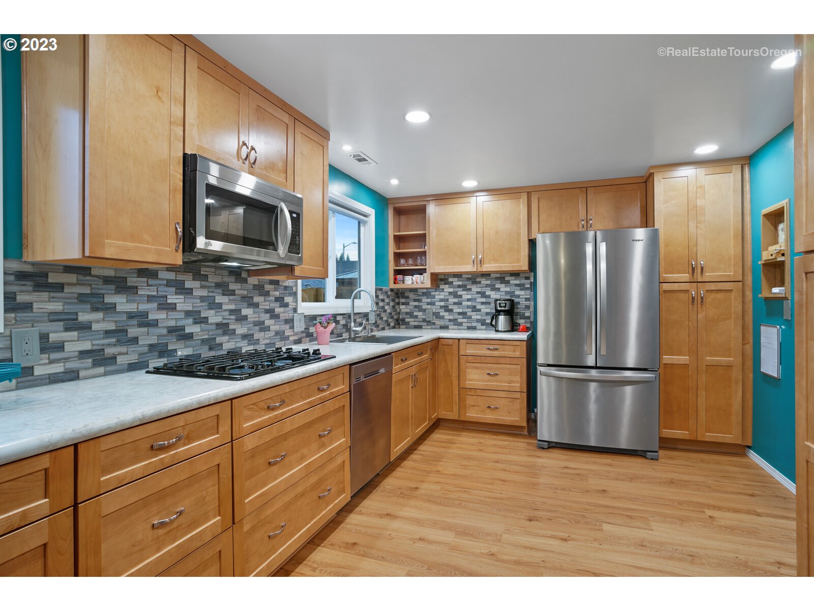 7325 Southwest 158th Place Beaverton, OR 97007 - Photo 5 of 28 a kitchen with stainless steel appliances granite countertop a refrigerator a stove a sink and a microwave