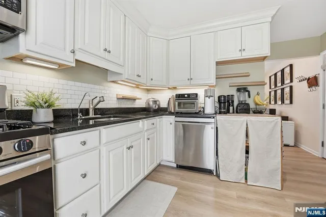 a kitchen with white cabinets and white appliances