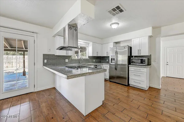a kitchen with wooden floor and cabinets