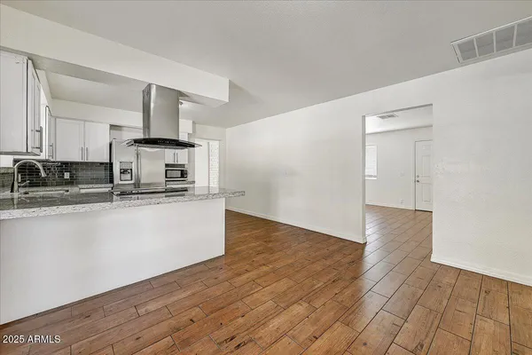 a kitchen with stainless steel appliances granite countertop a sink a stove and cabinets