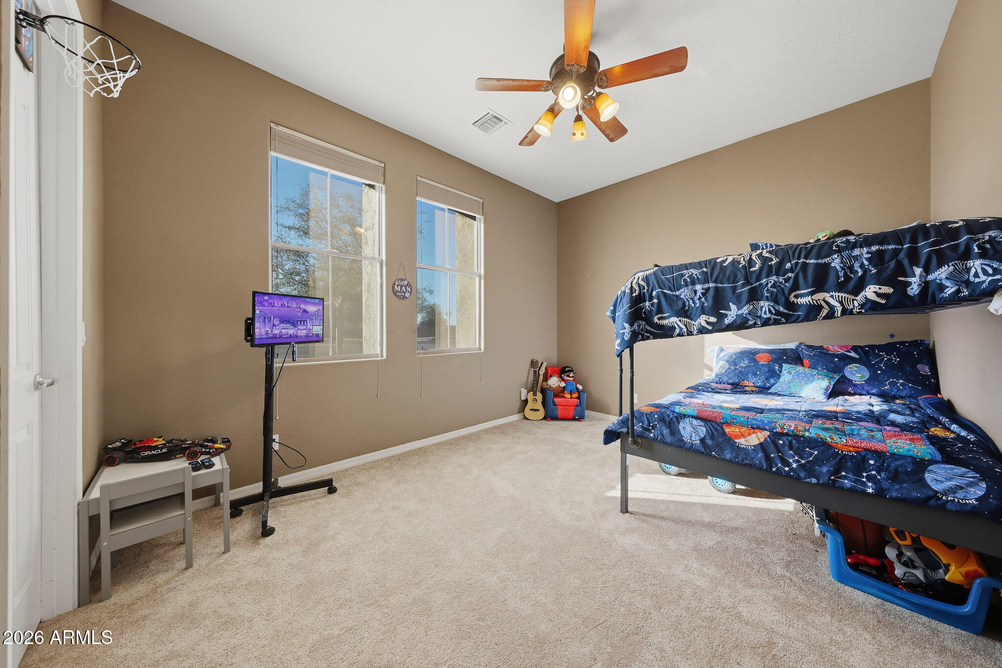 23024 West Sierra Ridge Way Wittmann, AZ 85361 - Photo 20 of 99 a bedroom with a bed and a chandelier