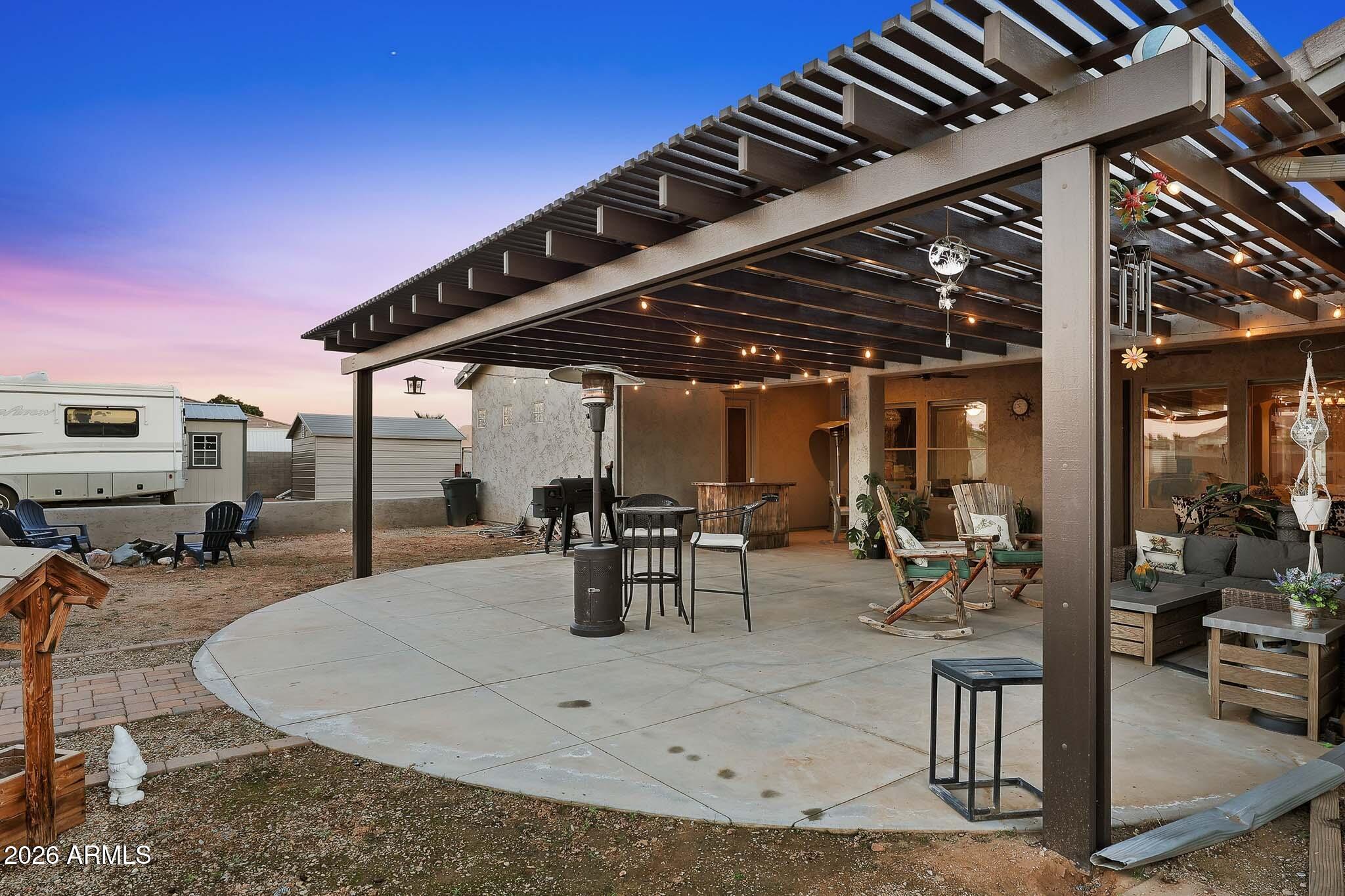 23024 West Sierra Ridge Way Wittmann, AZ 85361 - Photo 71 of 99 a view of a patio with dining table and chairs with wooden floor and fence