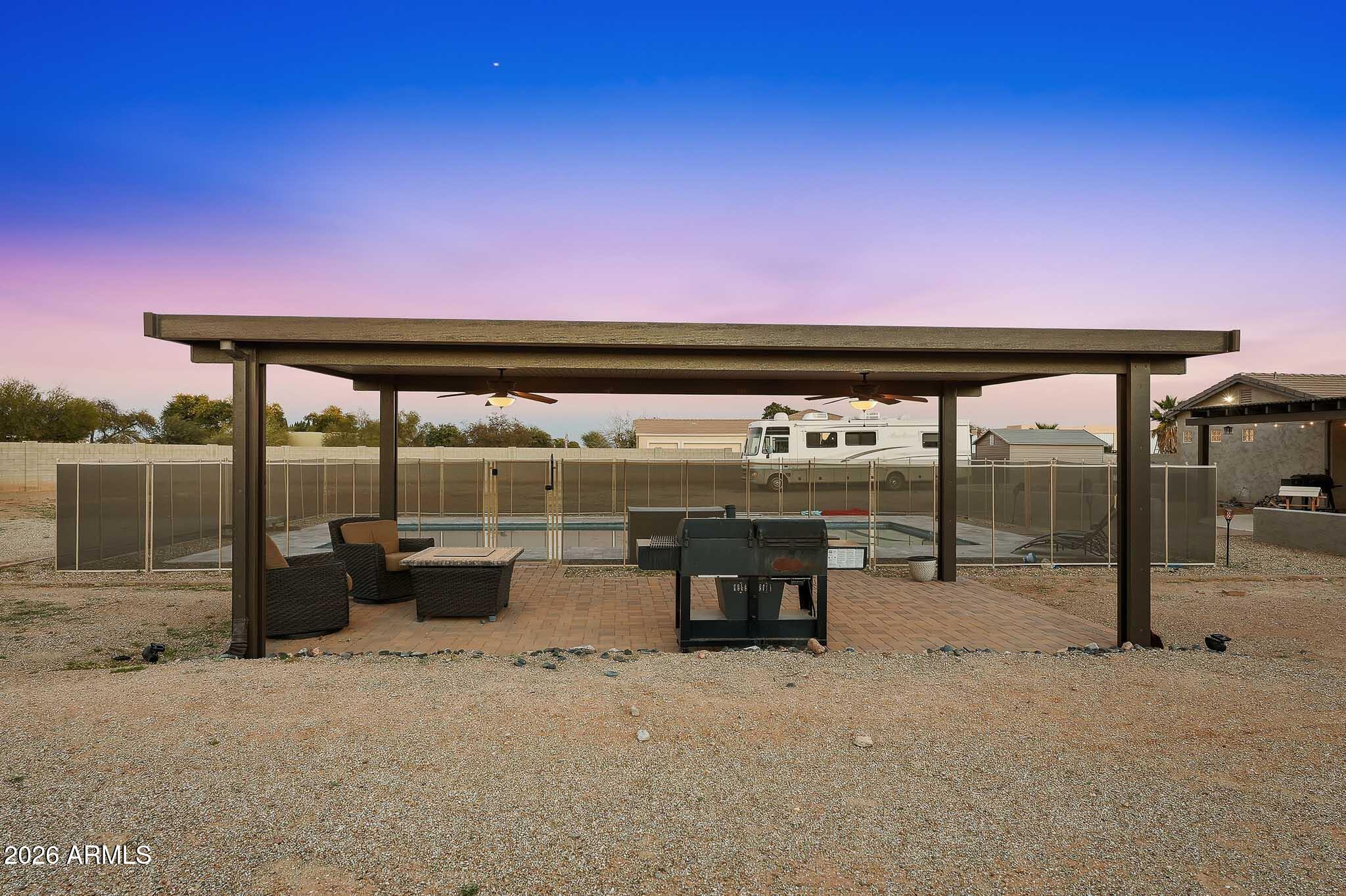 23024 West Sierra Ridge Way Wittmann, AZ 85361 - Photo 83 of 99 a roof deck with a table and chairs a barbeque