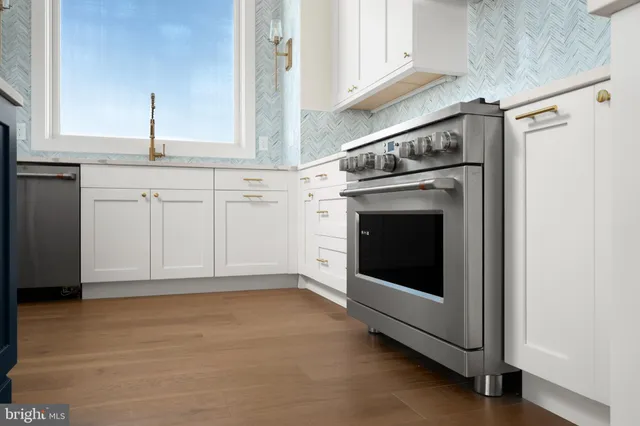 a view of a hallway with wooden floor and a bathroom