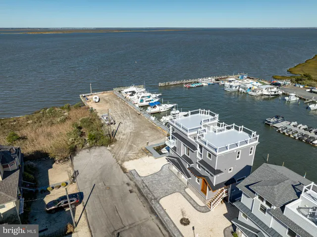 a large living room with wooden floors and kitchen view