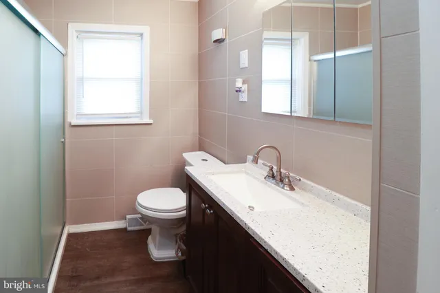 a bathroom with a sink toilet and a mirror
