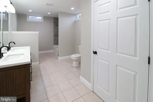 a bathroom with a sink a toilet and a mirror
