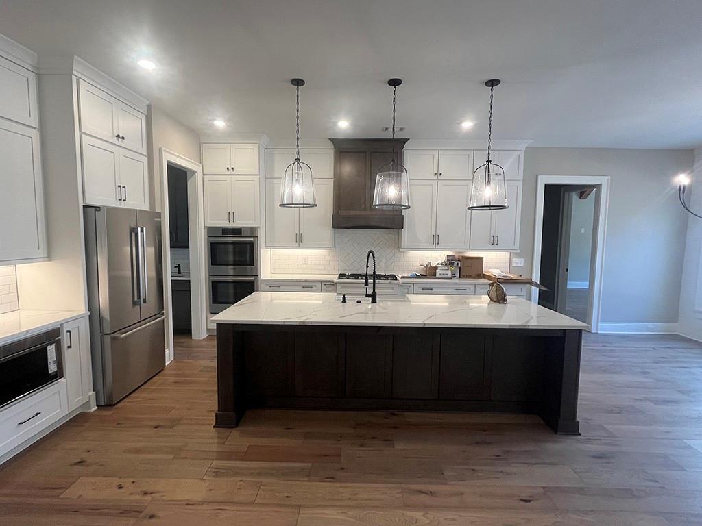 2200 Upper Burris Road Ball Ground, GA 30107 - Photo 49 of 79 a large kitchen with stainless steel appliances a large counter top a stove a refrigerator and a sink
