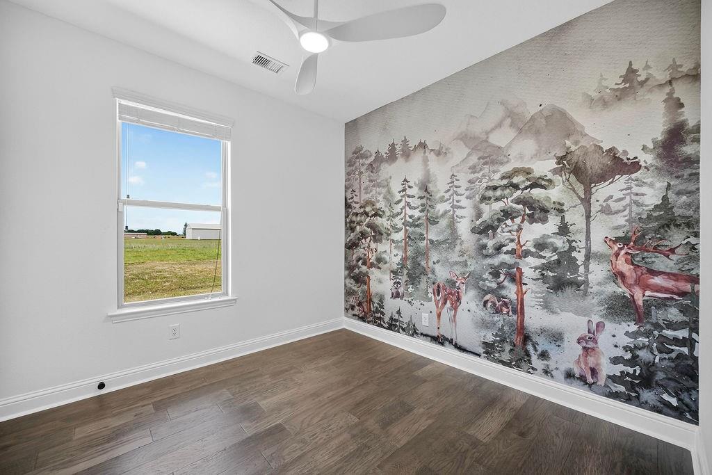 544 Gant Road Sherman, TX 75090 - Photo 26 of 39 Wood-finish flooring with white baseboards, a single window, and a ceiling fan with integrated lighting