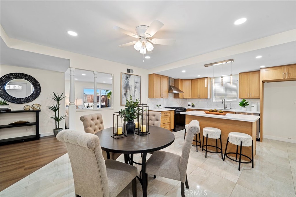 9561 Cardinal Avenue Westminster, CA 92683 - Photo 5 of 34 The chef’s dream kitchen is open to a spacious dining area and features quartz countertops and full backsplash, a center island with chic pendant lighting and bar seating, brand-new stainless appliances, a stainless farmhouse sink, and custom self-closing cabinetry with lazy Susans, spice storage, and deep pots-and-pans drawers