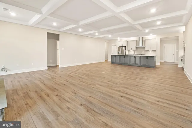 a view of a kitchen with kitchen island a sink wooden floor and a large window