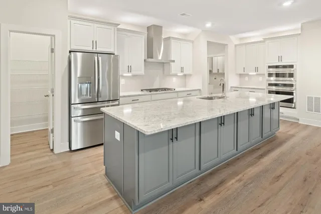 a kitchen with kitchen island white cabinets and stainless steel appliances