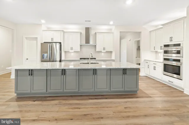 a kitchen with a sink and wooden floor