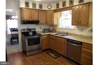 7250 Mackall Road St. Leonard, MD 20685 - Photo 2 of 27 a kitchen with stainless steel appliances granite countertop a sink a stove and a microwave