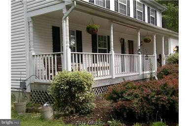 7250 Mackall Road St. Leonard, MD 20685 - Photo 13 of 27 a view of a house with a small yard and flower plants
