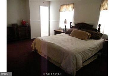 7250 Mackall Road St. Leonard, MD 20685 - Photo 5 of 27 a bedroom with a bed and wooden floor