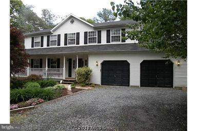 7250 Mackall Road St. Leonard, MD 20685 - Photo 6 of 27 a front view of a house with a yard and garage