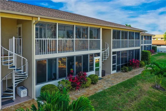 a view of a lake with a table and chairs under an umbrella next to a yard