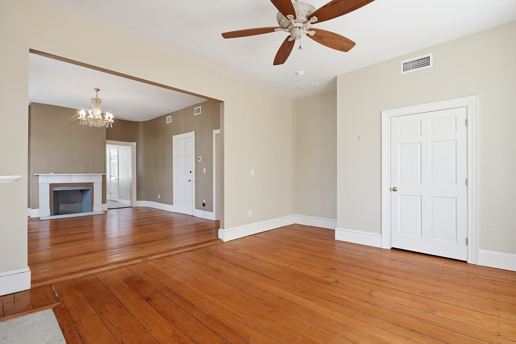 96 Washington Square East, Unit 2 Salem, MA 01970 - Photo 8 of 40 a view of a livingroom with a fireplace a ceiling fan and wooden floor