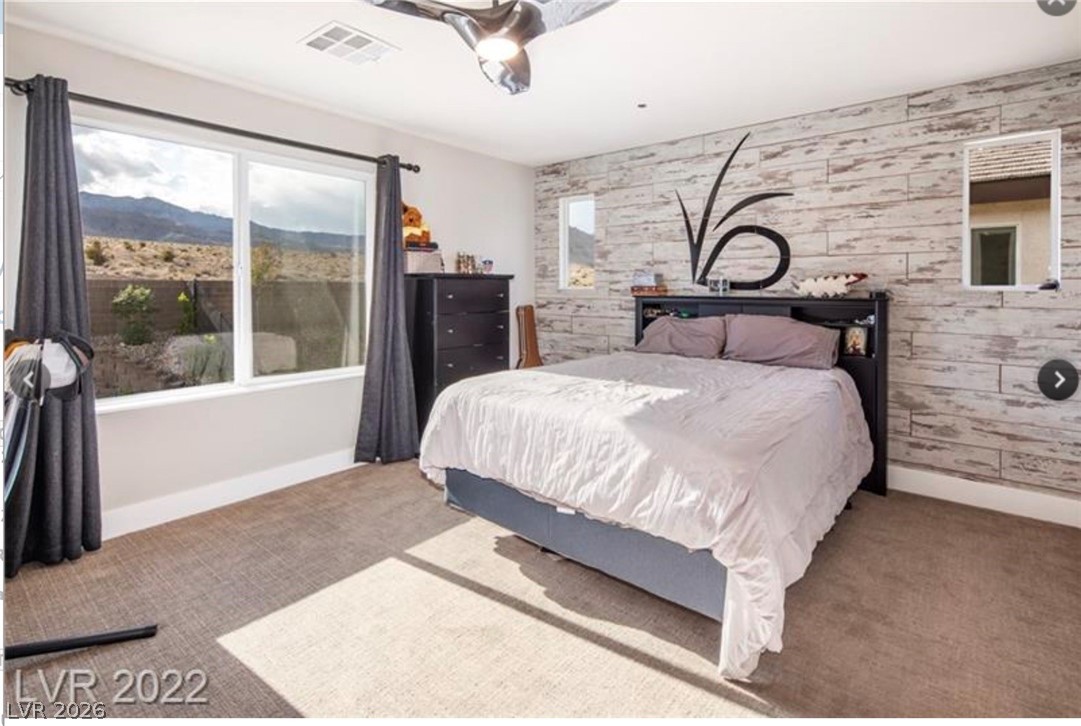 4631 Amazing View Street Las Vegas, NV 89129 - Photo 13 of 33 A desert-facing bedroom featuring a wood-plank accent wall and abundant natural light.