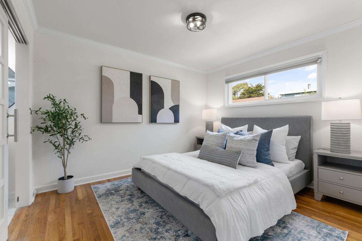 383 Monterey Road Pacifica, CA 94044 - Photo 11 of 33 a bedroom with a large bed and a potted plant