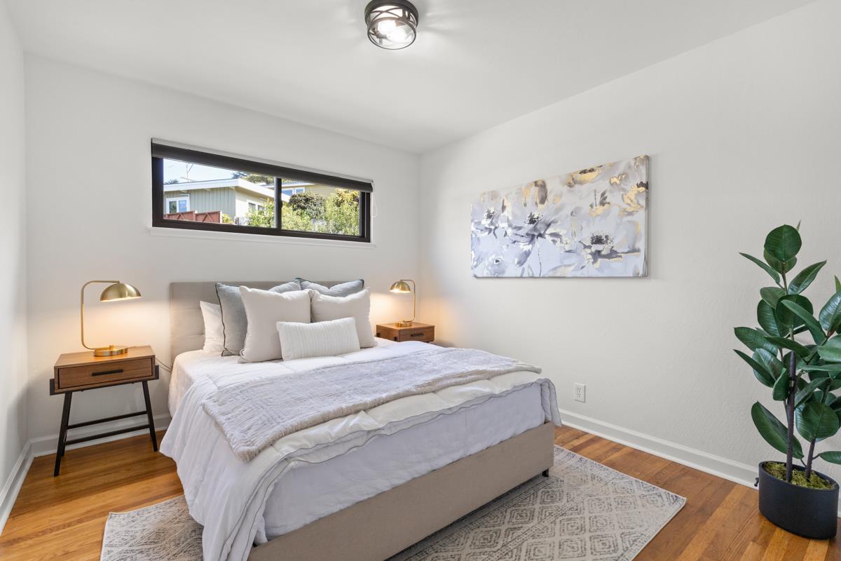 383 Monterey Road Pacifica, CA 94044 - Photo 17 of 33 a bedroom with bed and wooden floor