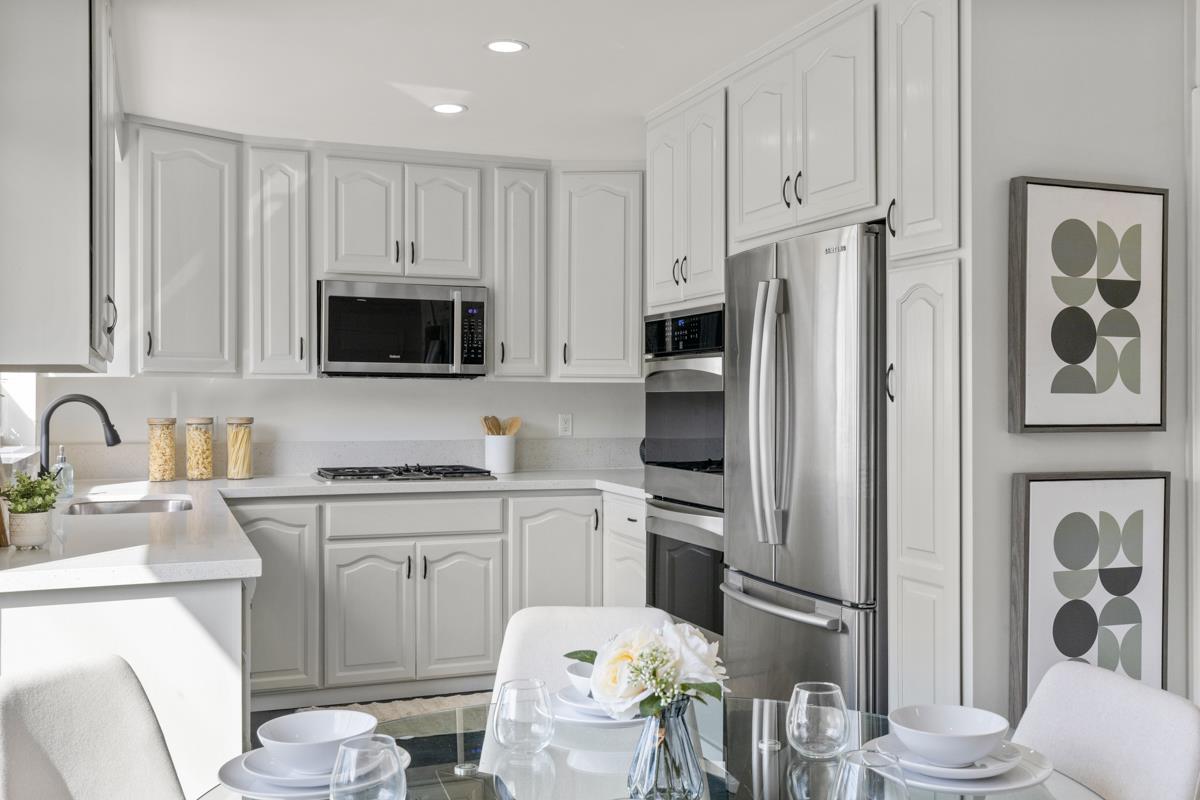 383 Monterey Road Pacifica, CA 94044 - Photo 8 of 33 a kitchen with stainless steel appliances a stove a sink a refrigerator a microwave a dining table and chairs