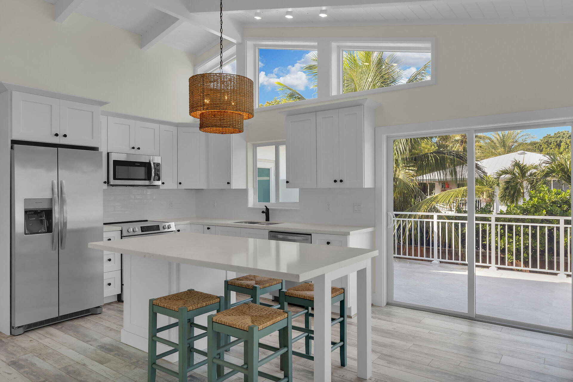 147 Sioux Street Tavernier, FL 33070 - Photo 11 of 41 a kitchen with stainless steel appliances granite countertop a stove a refrigerator a sink a dining table and chairs with wooden floor