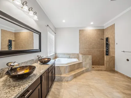 a spacious bathroom with a granite countertop sink a toilet a mirror and bathtub