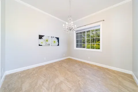 an empty room with windows and chandelier