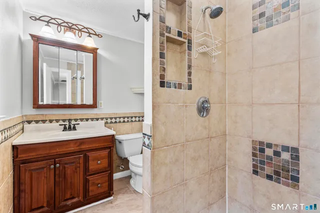 a bathroom with a toilet a sink and mirror