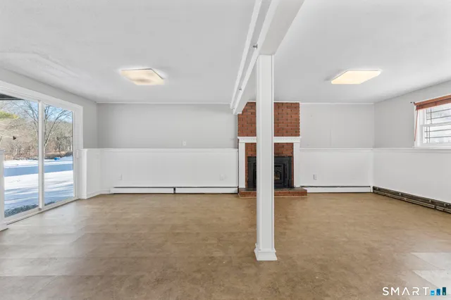 a view of an empty room with a fireplace and a window