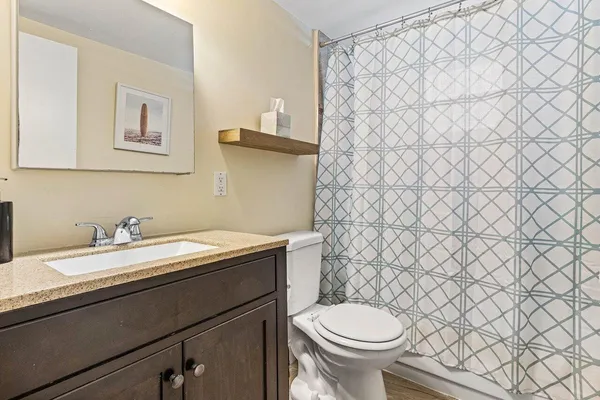 a bathroom with a granite countertop toilet and sink