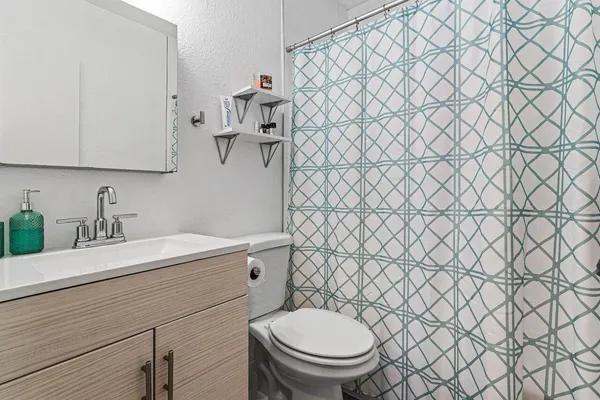 a bathroom with a granite countertop toilet and sink