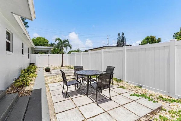 a view of a patio with table and chairs and potted plants