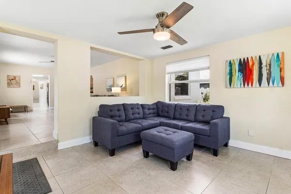 a living room with furniture ceiling fan and a rug
