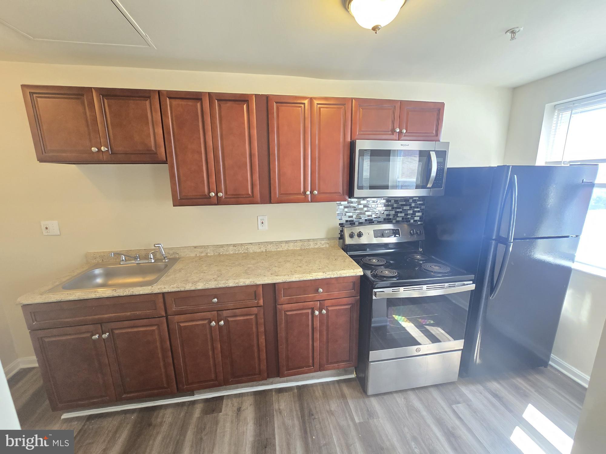 317 North Avenue East, Unit 112 Baltimore, MD 21202 - Photo 1 of 11 a kitchen with a sink a stove and cabinets