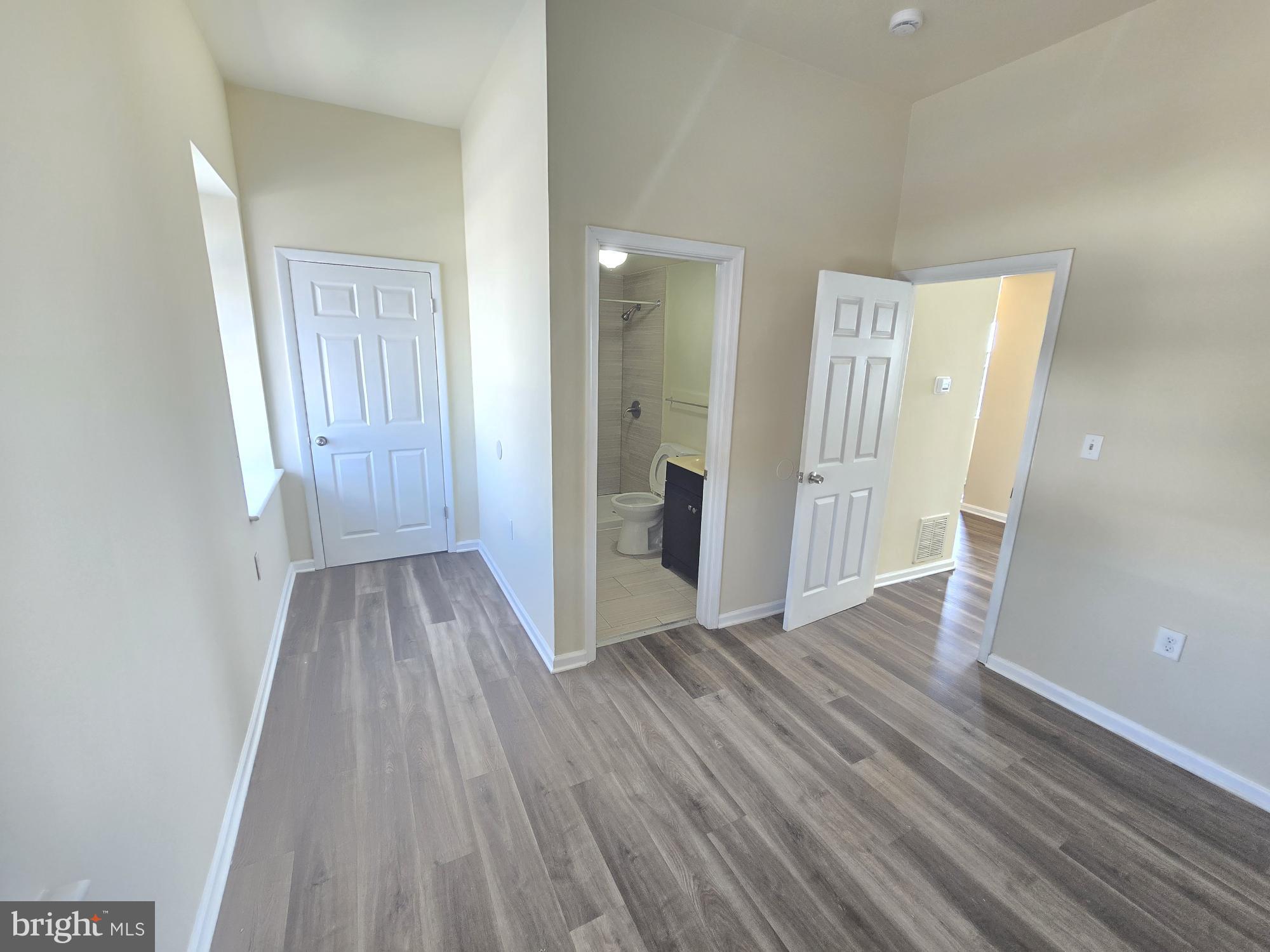 317 North Avenue East, Unit 112 Baltimore, MD 21202 - Photo 11 of 11 a view of a hallway with wooden floor and a bathroom