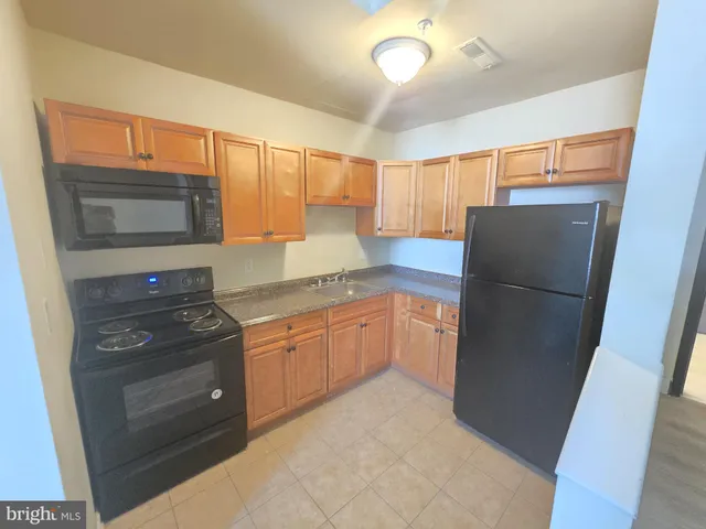 a kitchen with granite countertop a refrigerator and a sink