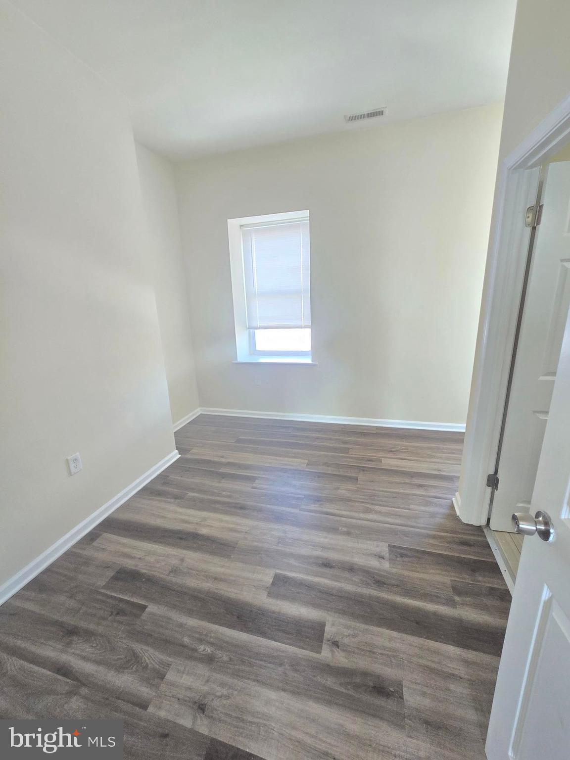 317 North Avenue East, Unit 112 Baltimore, MD 21202 - Photo 10 of 11 a view of an empty room with wooden floor and window