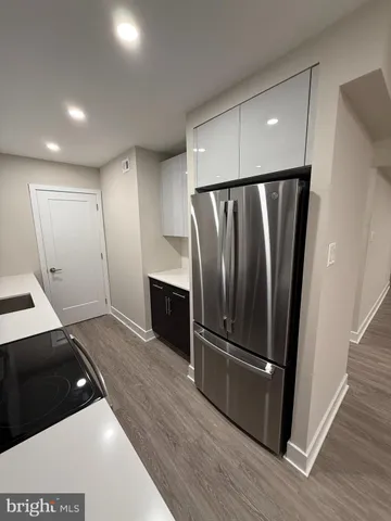 a kitchen with stainless steel appliances a refrigerator and wooden floor