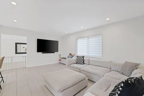 a living room with furniture a dining table and kitchen view