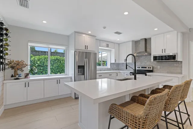 a kitchen with stainless steel appliances a refrigerator sink and white cabinets