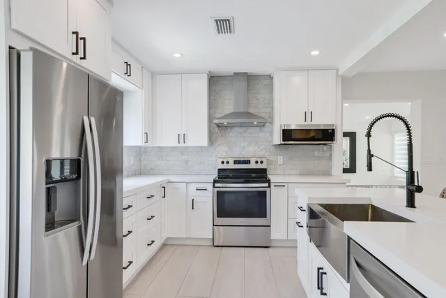 a kitchen with white cabinets and stainless steel appliances