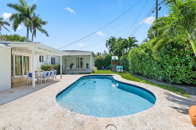 a view of a patio with a table and chairs under an umbrella